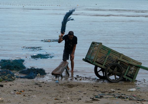 In Bantaeng Regency, South Sulawesi in Indonesia, farmers smash used lines on wood in order to remove any unwanted residues on the line.