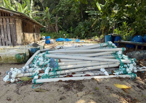Brazil: Pile of PVC pipe float assemblies, each fitted with buoyant ends and rope, ready for installation on modular seaweed raft systems.